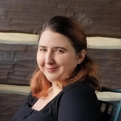 Administrative Assistant Kyia Money Smiling In Front Of Wooden Wall